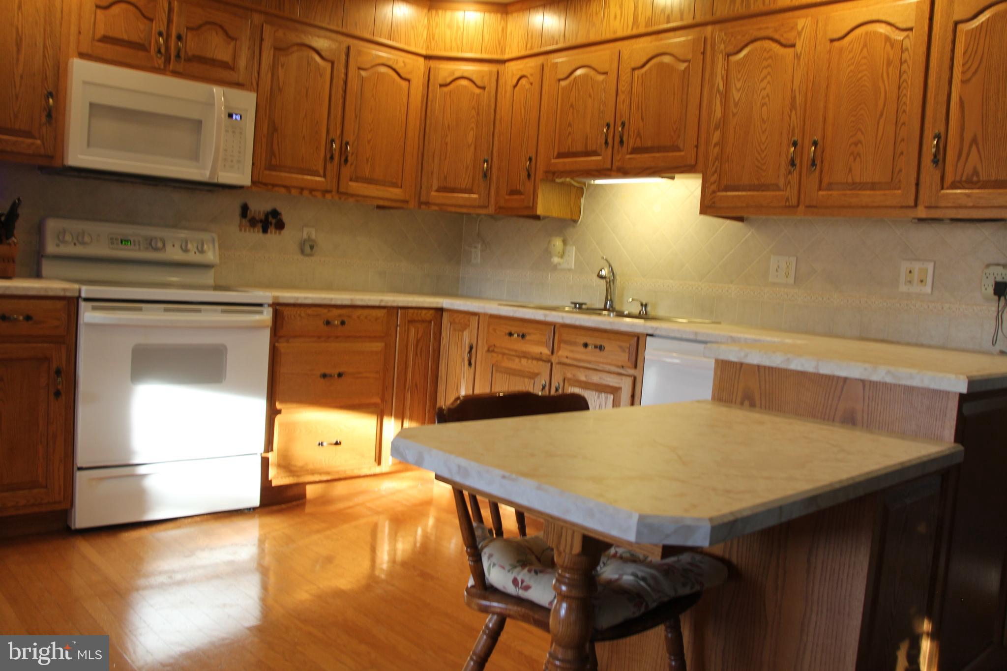 668 Snyder Hill Road Lititz, PA 17543 - Photo 17 of 32 a kitchen with stainless steel appliances wooden cabinets a stove a sink and a microwave