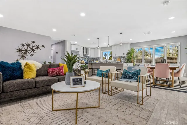 a living room with furniture potted plant and kitchen view