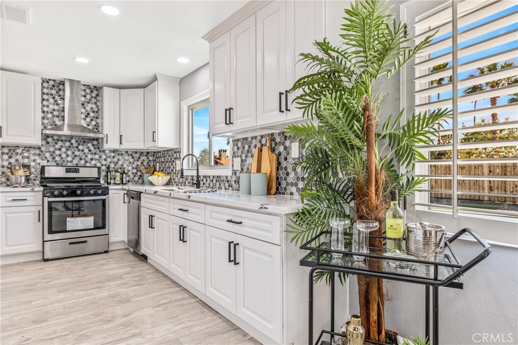 373 East Simms Road Palm Springs, CA 92262 - Photo 22 of 24 a kitchen with stainless steel appliances a sink a stove top oven a chimney and cabinets