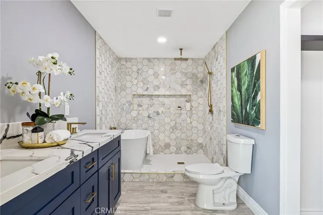 a bathroom with a granite countertop sink toilet and shower