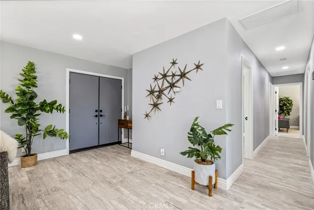 a view of a hallway with wooden floor and a potted plant