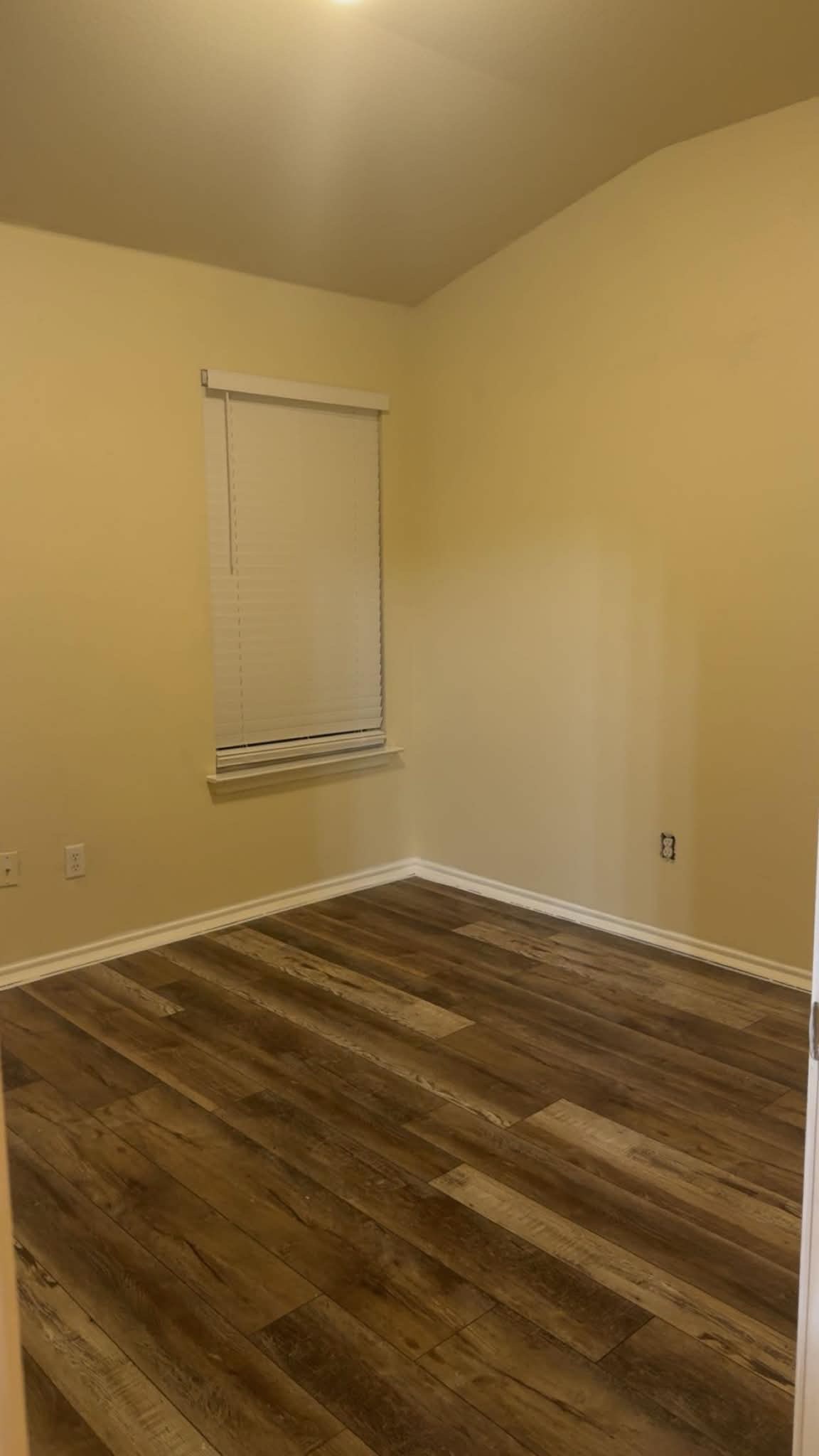 13004 Tinker Street Manor, TX 78653 - Photo 7 of 9 A quiet secondary bedroom features durable wood-look flooring and a window with blinds for privacy.