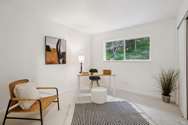a bedroom with a bed a window and a chair