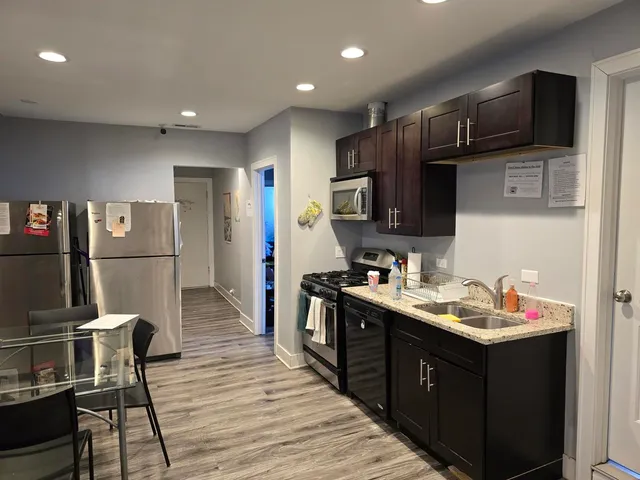 a kitchen with stainless steel appliances granite countertop a refrigerator and a stove top oven