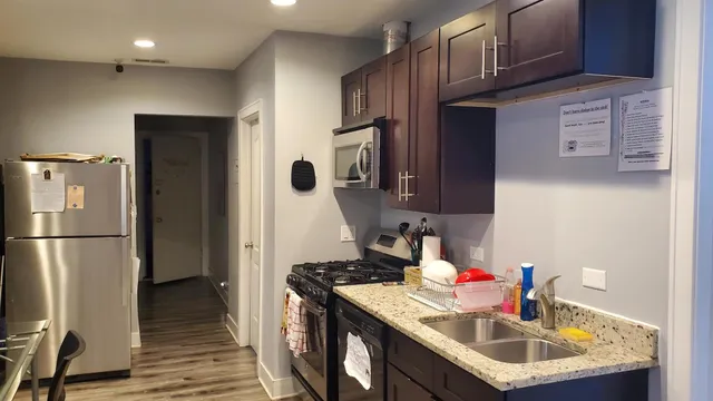a kitchen with kitchen island granite countertop a sink stove and refrigerator