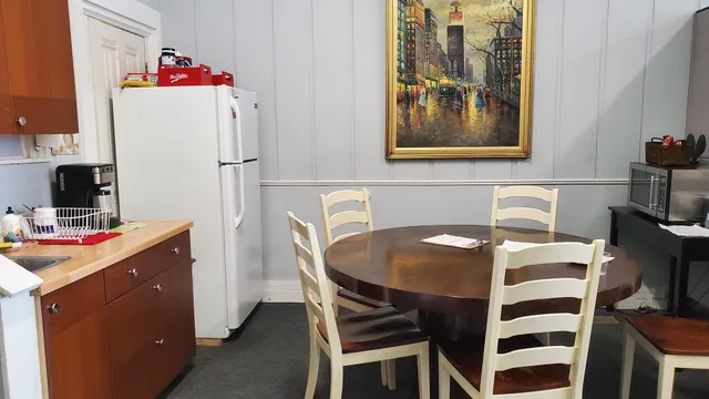 a table and a refrigerator sitting in a kitchen