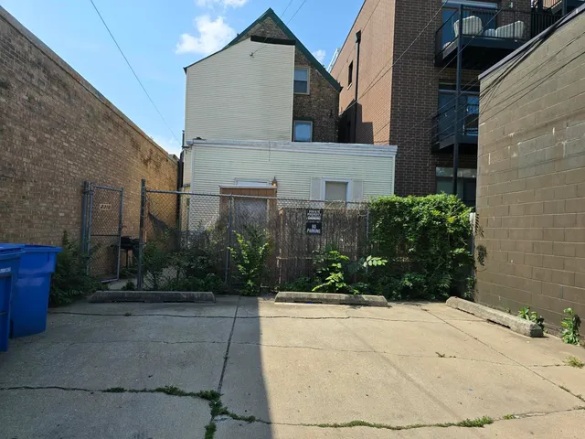 a view of a white house with a yard potted plants