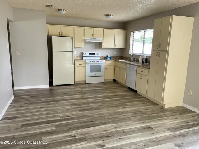 a kitchen with white cabinets and white appliances