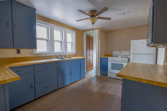 a kitchen with stainless steel appliances granite countertop a sink a stove and a refrigerator