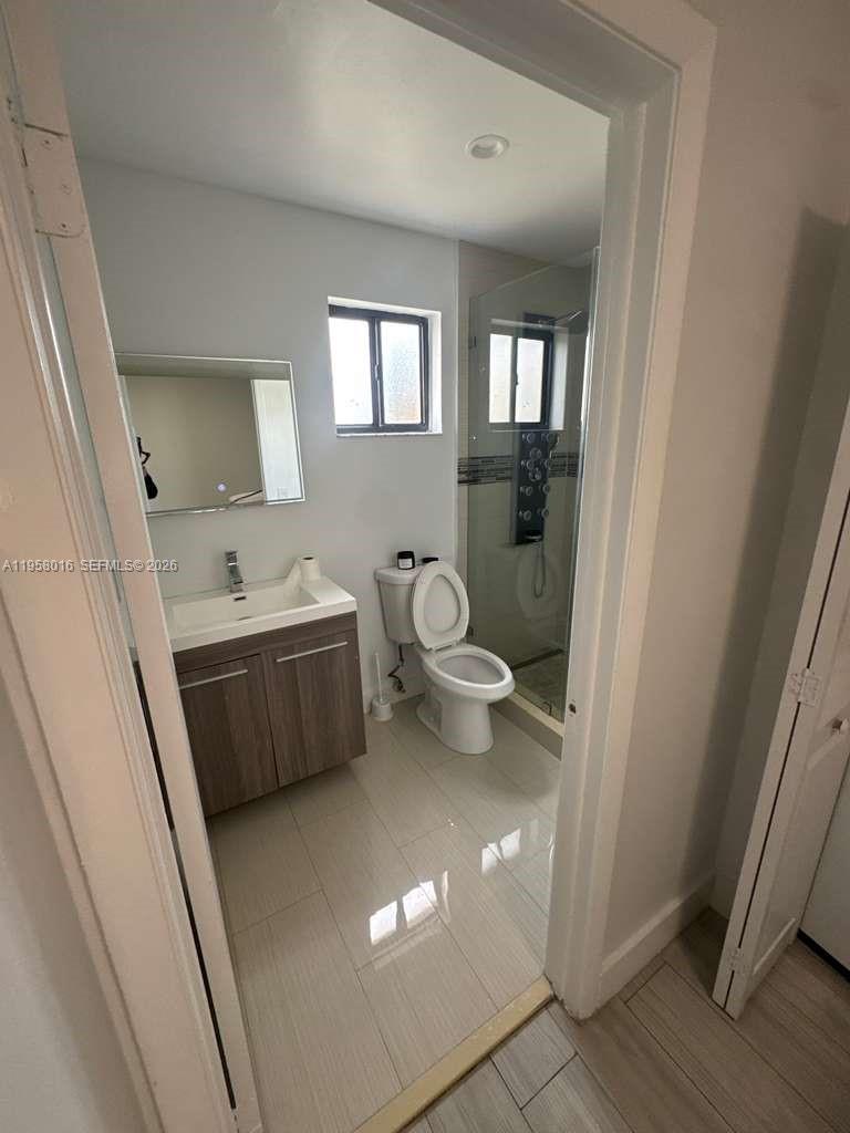 10034 Southwest 221st Street Cutler Bay, FL 33190 - Photo 11 of 25 a bathroom with a double vanity sink toilet and shower