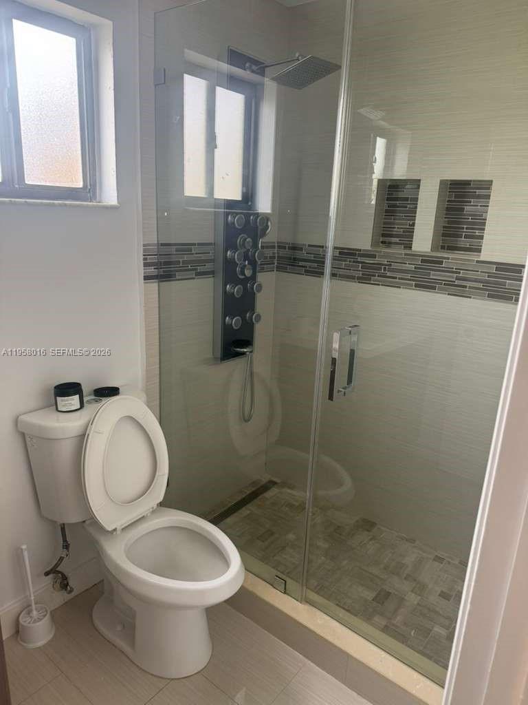 10034 Southwest 221st Street Cutler Bay, FL 33190 - Photo 12 of 25 a bathroom with a toilet and a shower