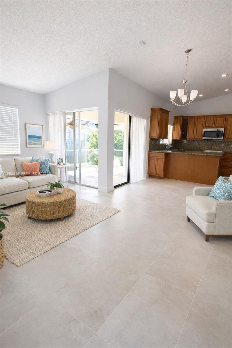 10034 Southwest 221st Street Cutler Bay, FL 33190 - Photo 3 of 25 a living room with furniture and a chandelier