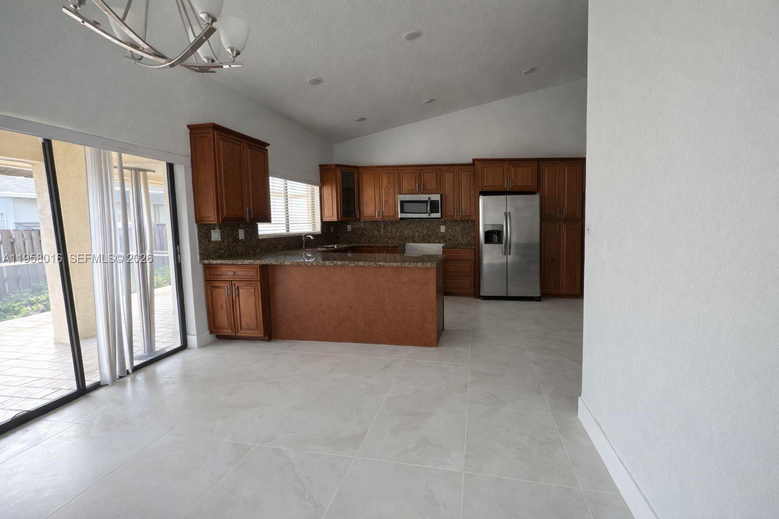 10034 Southwest 221st Street Cutler Bay, FL 33190 - Photo 4 of 25 a kitchen with refrigerator and window