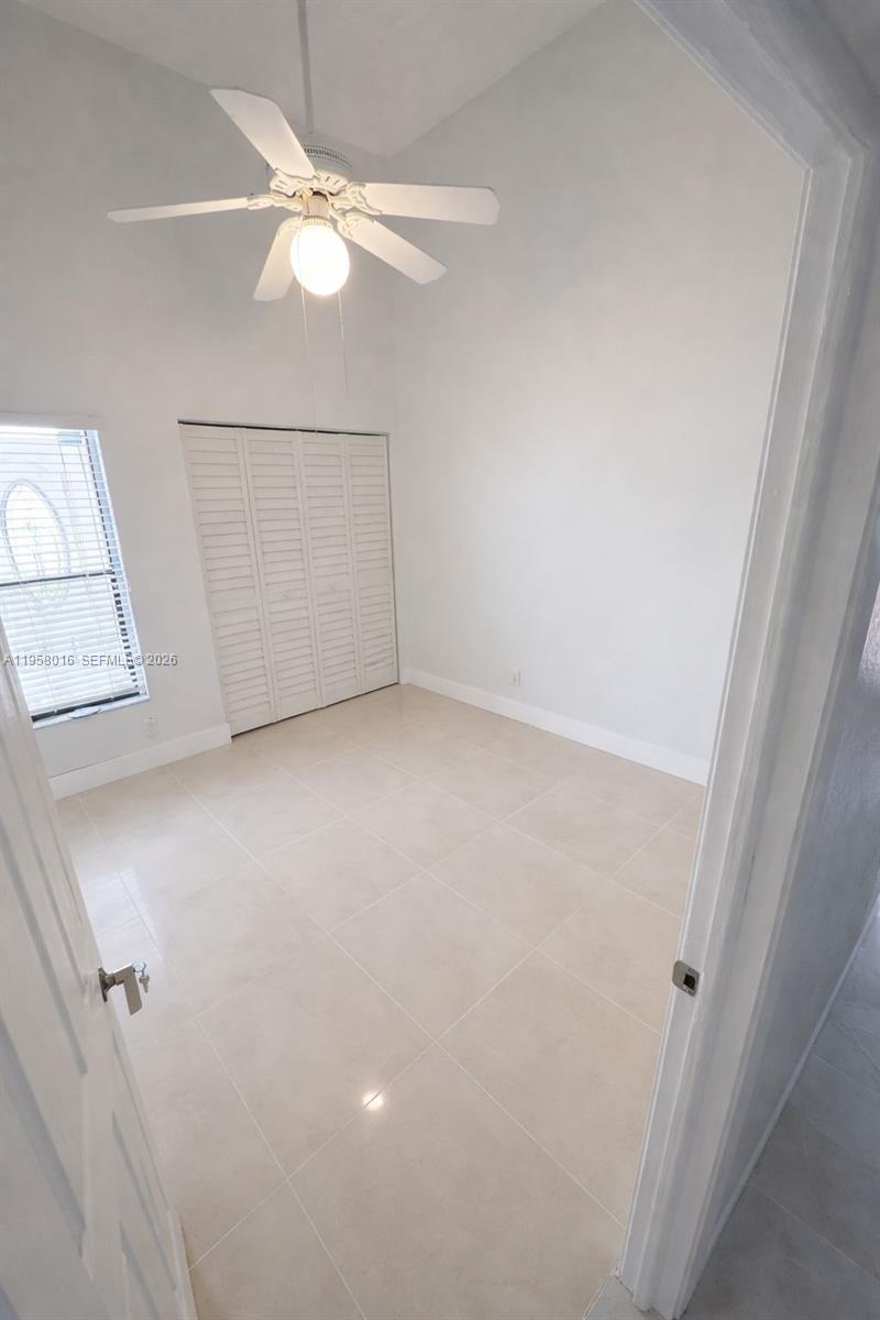 10034 Southwest 221st Street Cutler Bay, FL 33190 - Photo 6 of 25 an empty room with a ceiling fan and a window