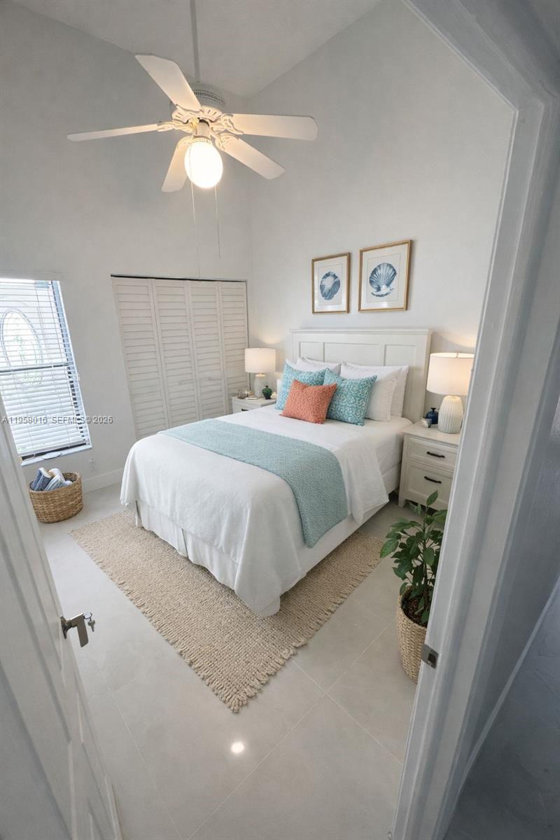 10034 Southwest 221st Street Cutler Bay, FL 33190 - Photo 7 of 25 a bedroom with a large bed and a chandelier