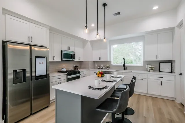 a kitchen with a center island appliances and cabinets