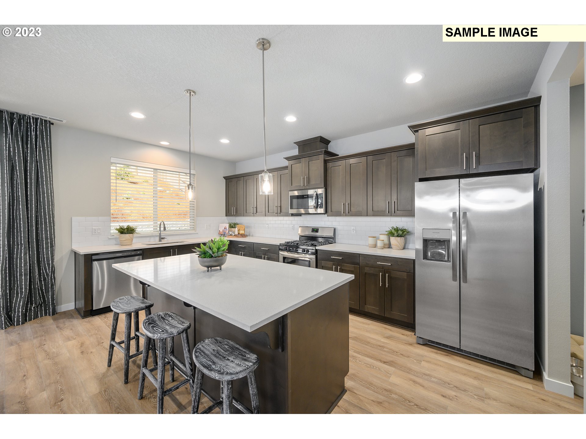 41510 Metolius Avenue, Unit 16 Sandy, OR 97055 - Photo 12 of 40 a kitchen with kitchen island a refrigerator sink stove dining table and chairs