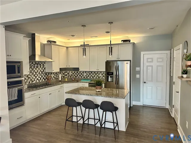 a kitchen with granite countertop white cabinets and stainless steel appliances