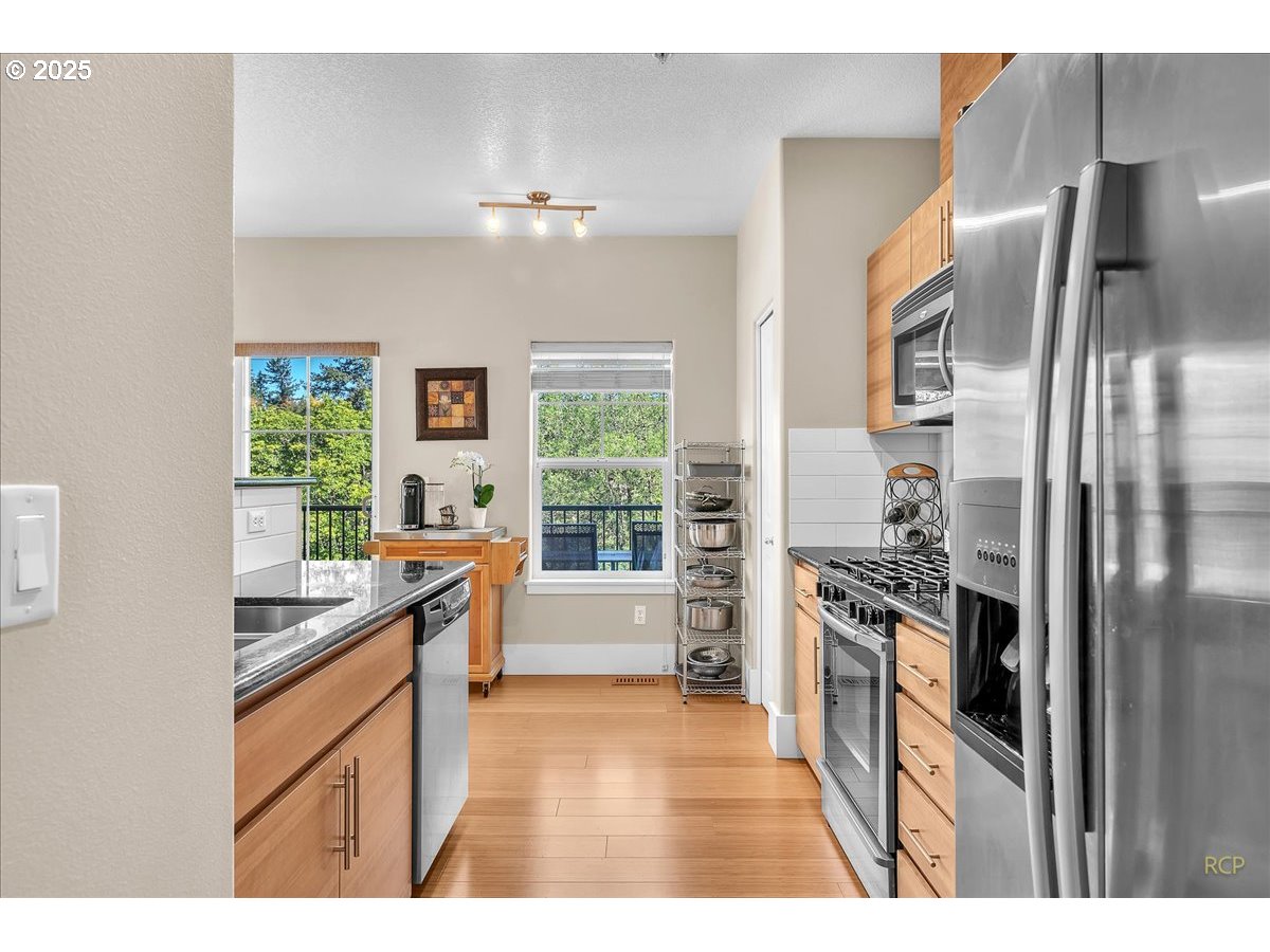 794 Northwest 118th Avenue, Unit 101 Portland, OR 97229 - Photo 12 of 41 a kitchen with stainless steel appliances granite countertop a refrigerator a sink a stove and oven