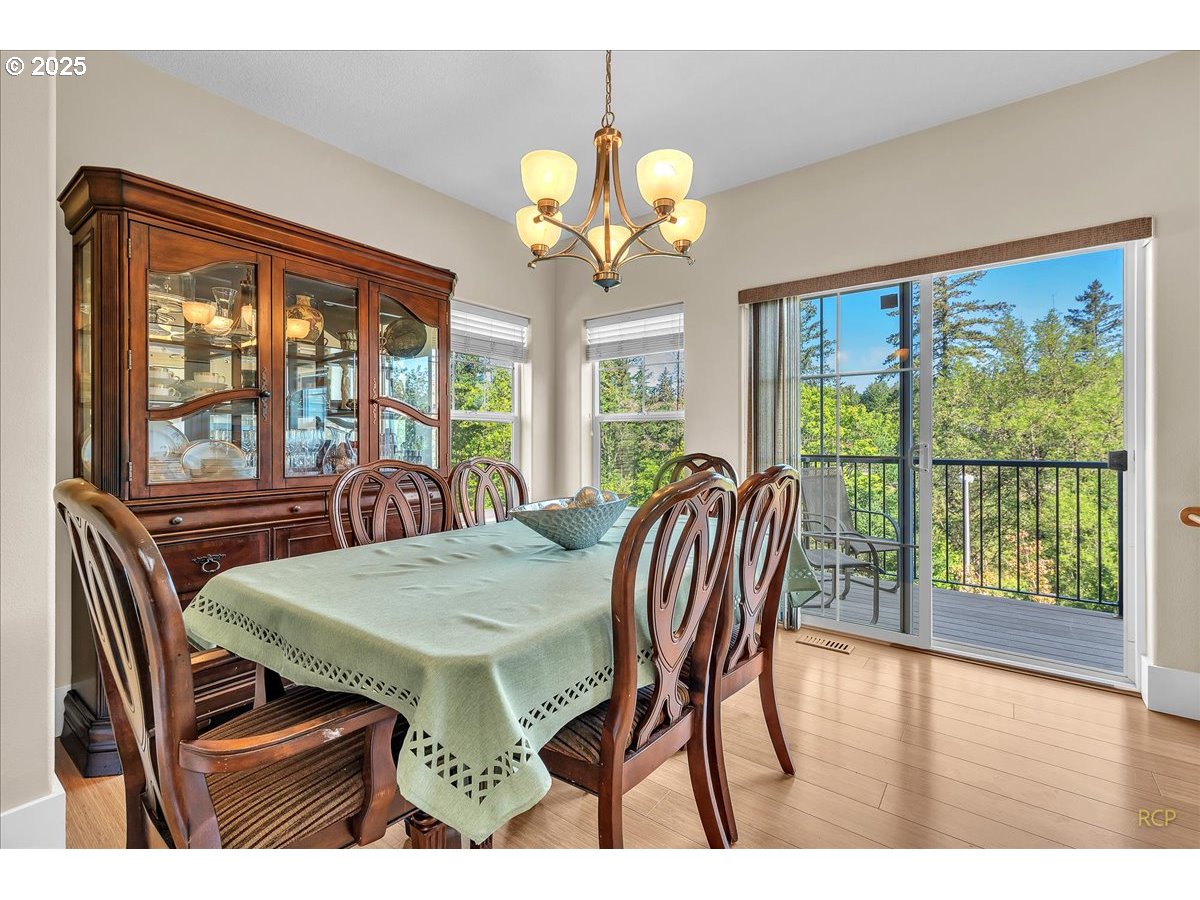 794 Northwest 118th Avenue, Unit 101 Portland, OR 97229 - Photo 18 of 41 a view of a dining room with furniture a chandelier and wooden floor