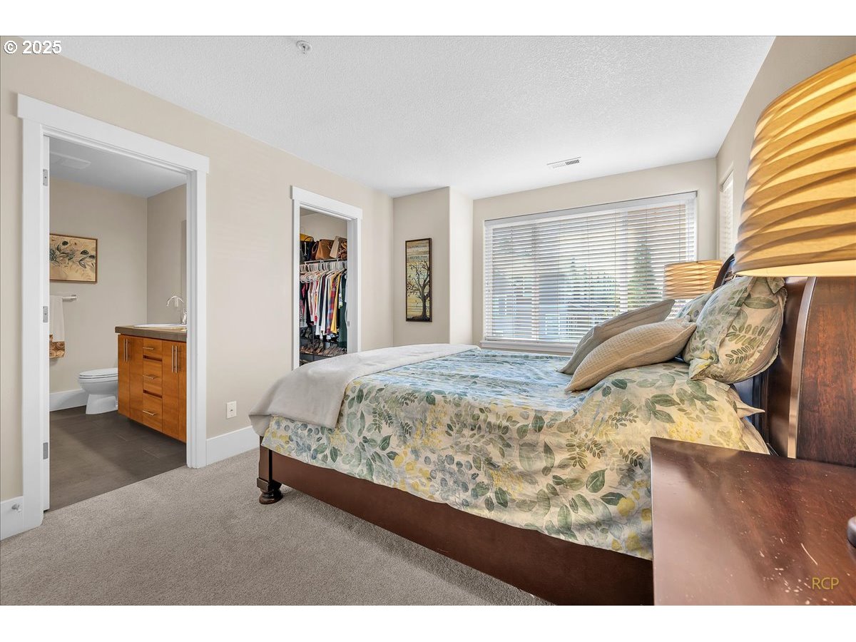 794 Northwest 118th Avenue, Unit 101 Portland, OR 97229 - Photo 24 of 41 a bed sitting in a bedroom next to a window