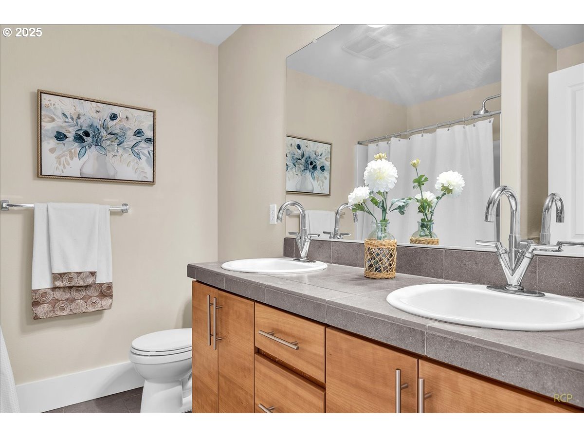 794 Northwest 118th Avenue, Unit 101 Portland, OR 97229 - Photo 26 of 41 a bathroom with a granite countertop toilet a sink and a mirror