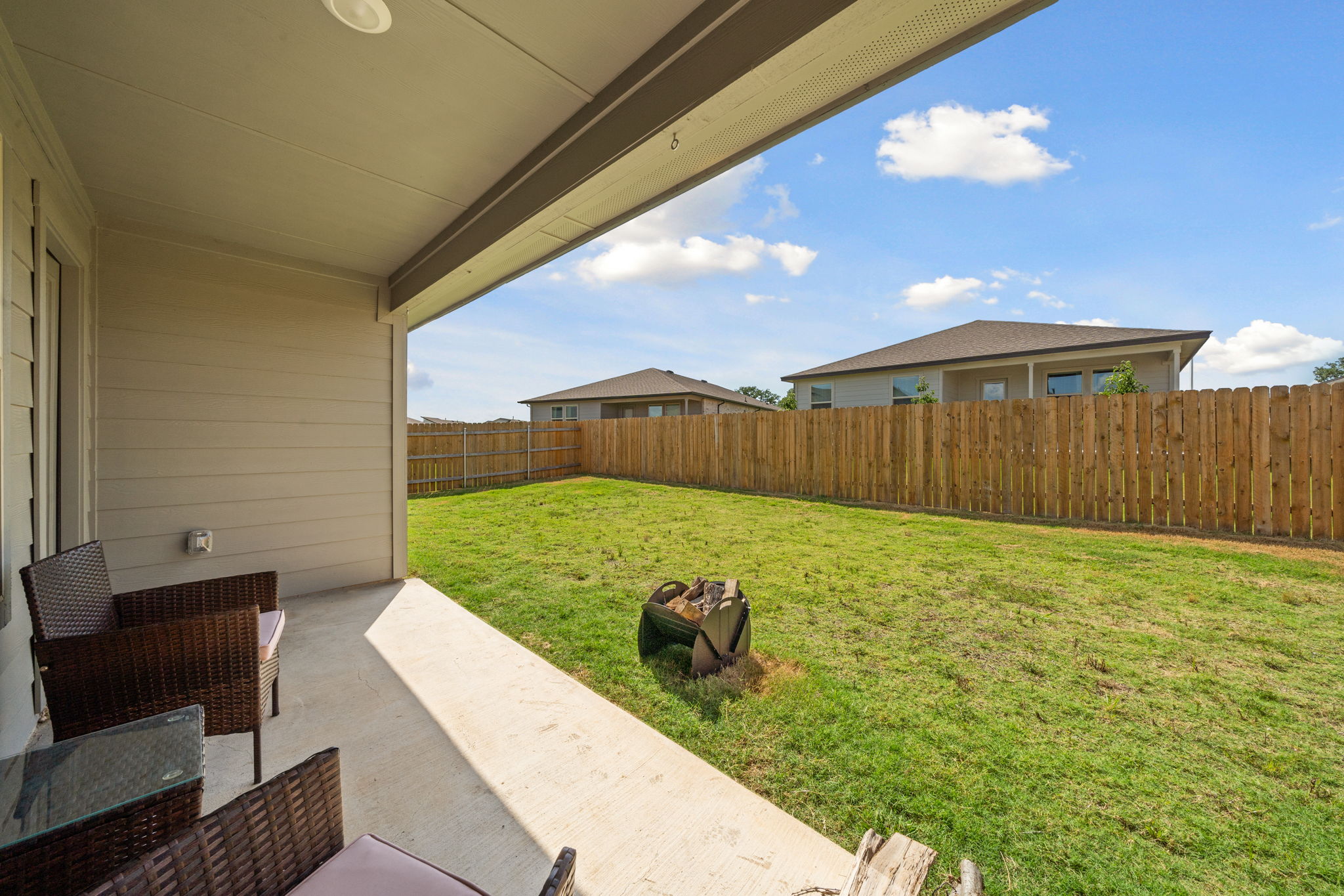 1117 Tipton Street Georgetown, TX 78633 - Photo 37 of 40 Covered outdoor patio with a concrete surface, leading to a fenced backyard featuring a wooden privacy fence and a grass lawn
