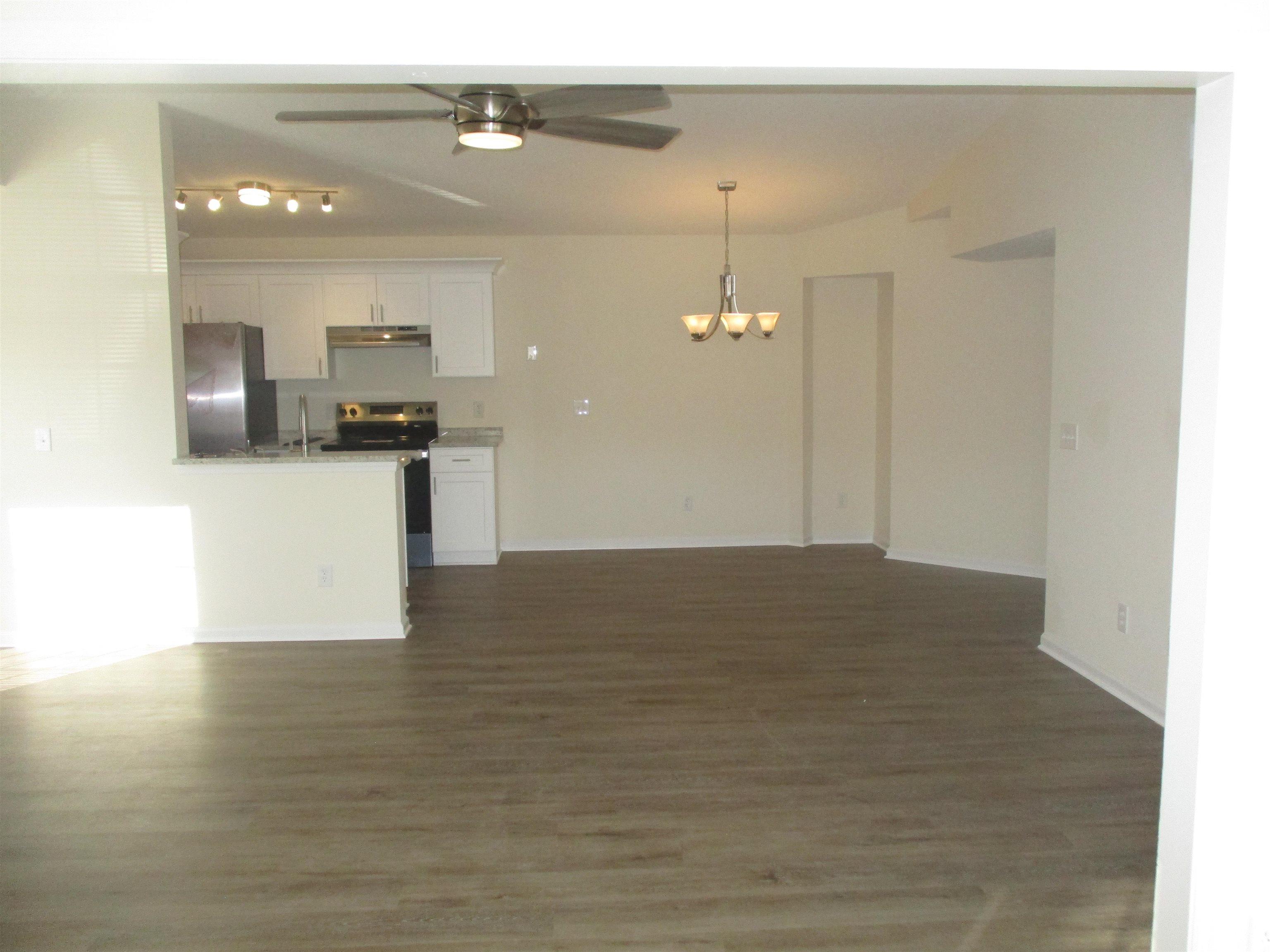 8545 Hopkins Circle Surfside Beach, SC 29575 - Photo 24 of 24 Kitchen featuring open floor plan, appliances with stainless steel finishes, white cabinets, a chandelier, and dark wood-style floors