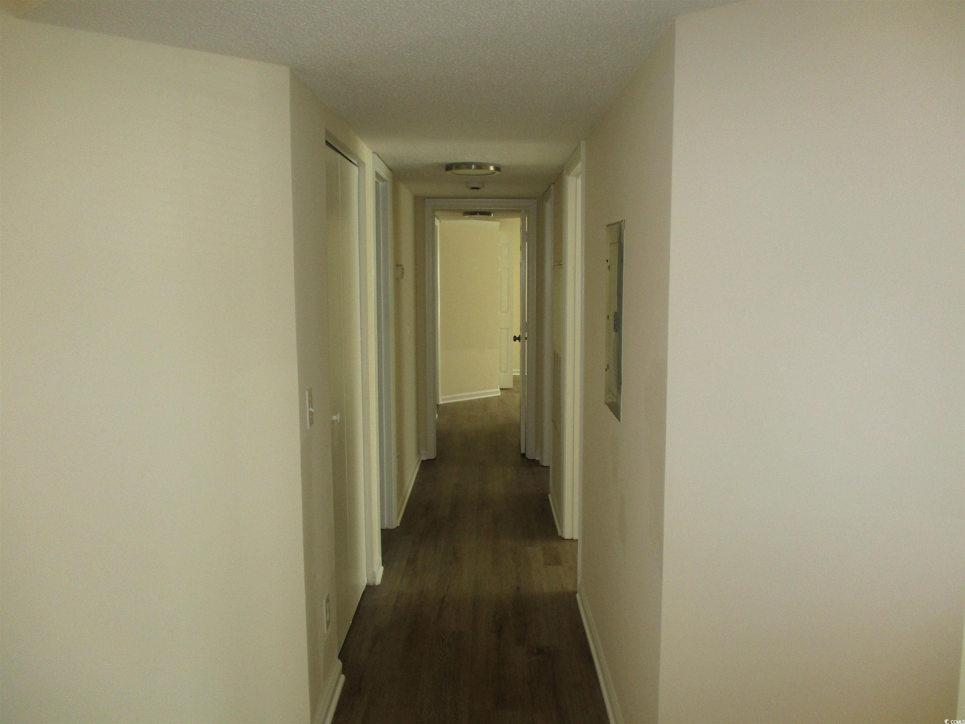 8545 Hopkins Circle Surfside Beach, SC 29575 - Photo 11 of 24 Corridor with a textured ceiling and dark wood finished floors