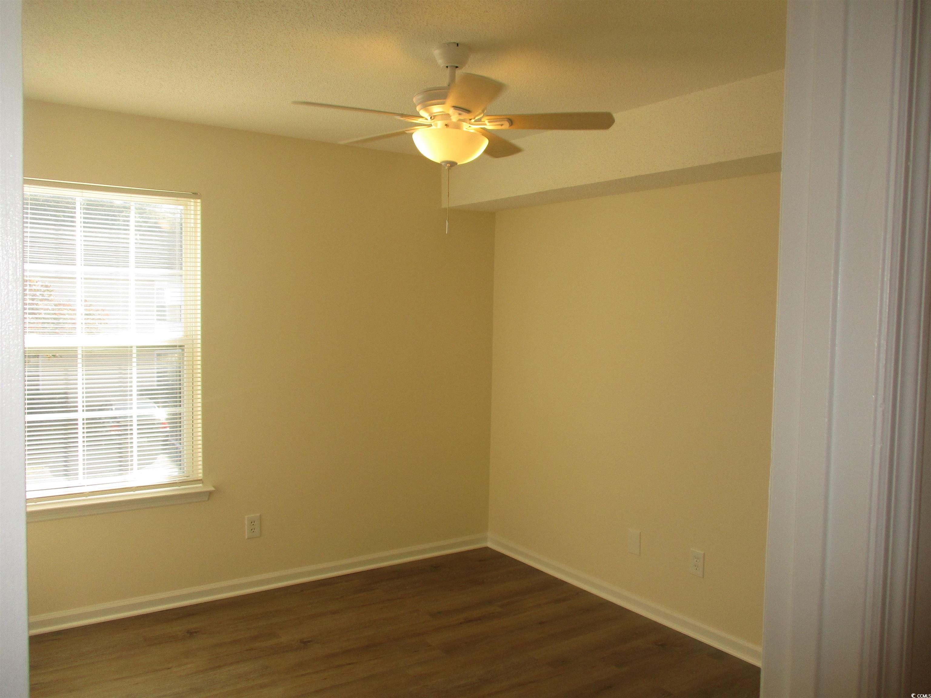 8545 Hopkins Circle Surfside Beach, SC 29575 - Photo 13 of 24 Unfurnished room with dark wood-style floors and ceiling fan