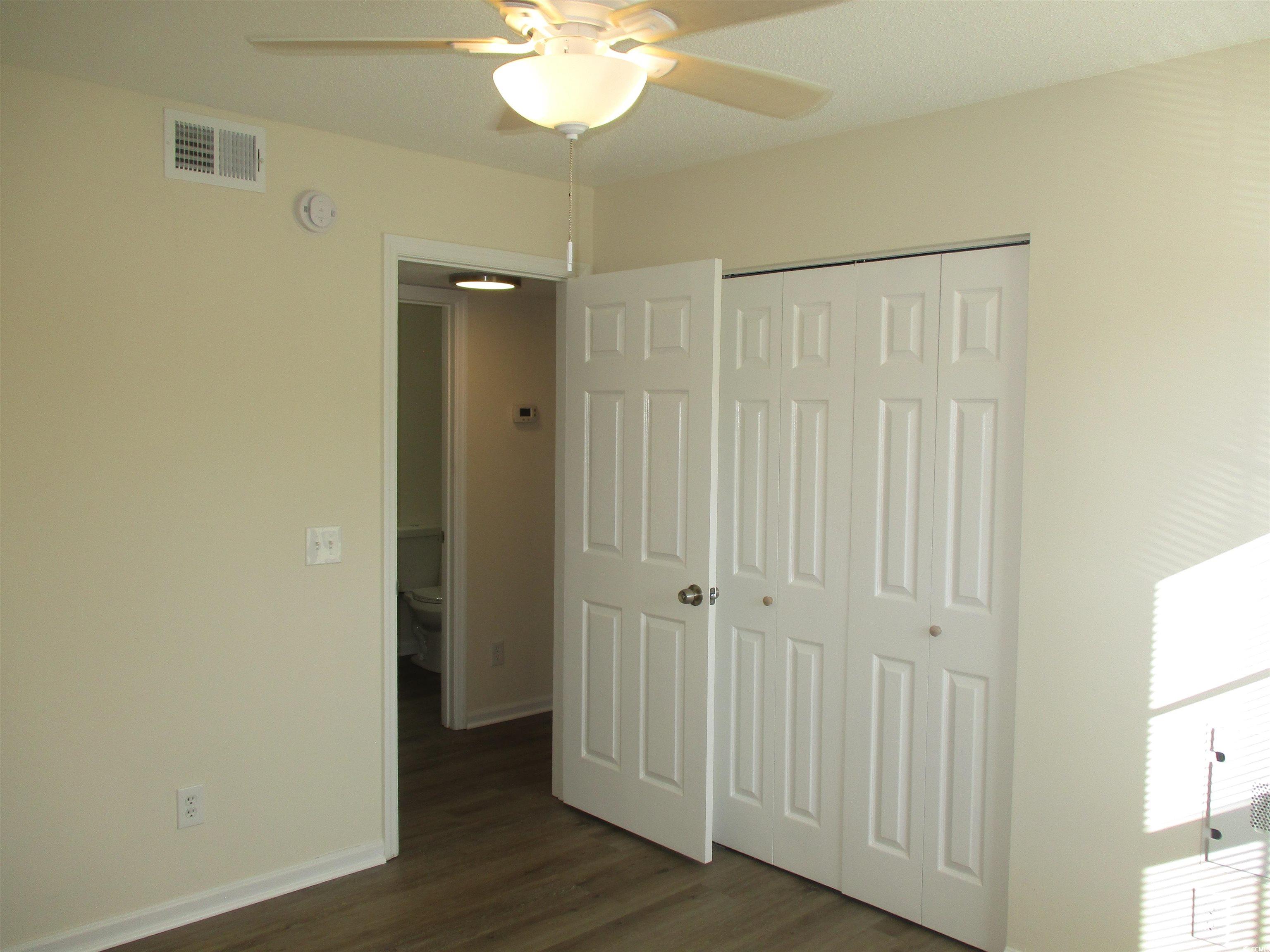8545 Hopkins Circle Surfside Beach, SC 29575 - Photo 14 of 24 Unfurnished bedroom with dark wood-style flooring, a closet, and ceiling fan