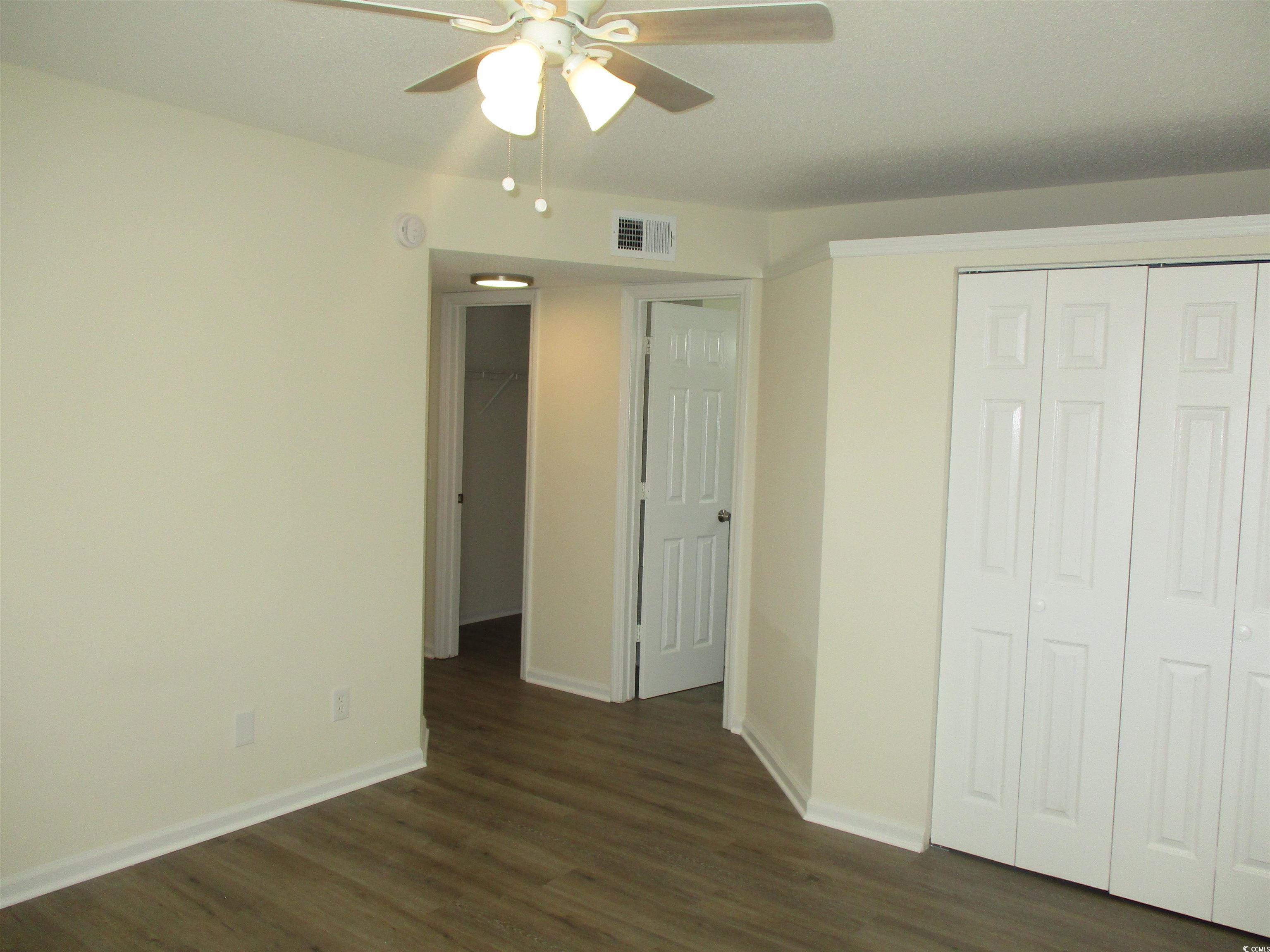 8545 Hopkins Circle Surfside Beach, SC 29575 - Photo 20 of 24 Unfurnished bedroom featuring a closet, dark wood-type flooring, and a ceiling fan