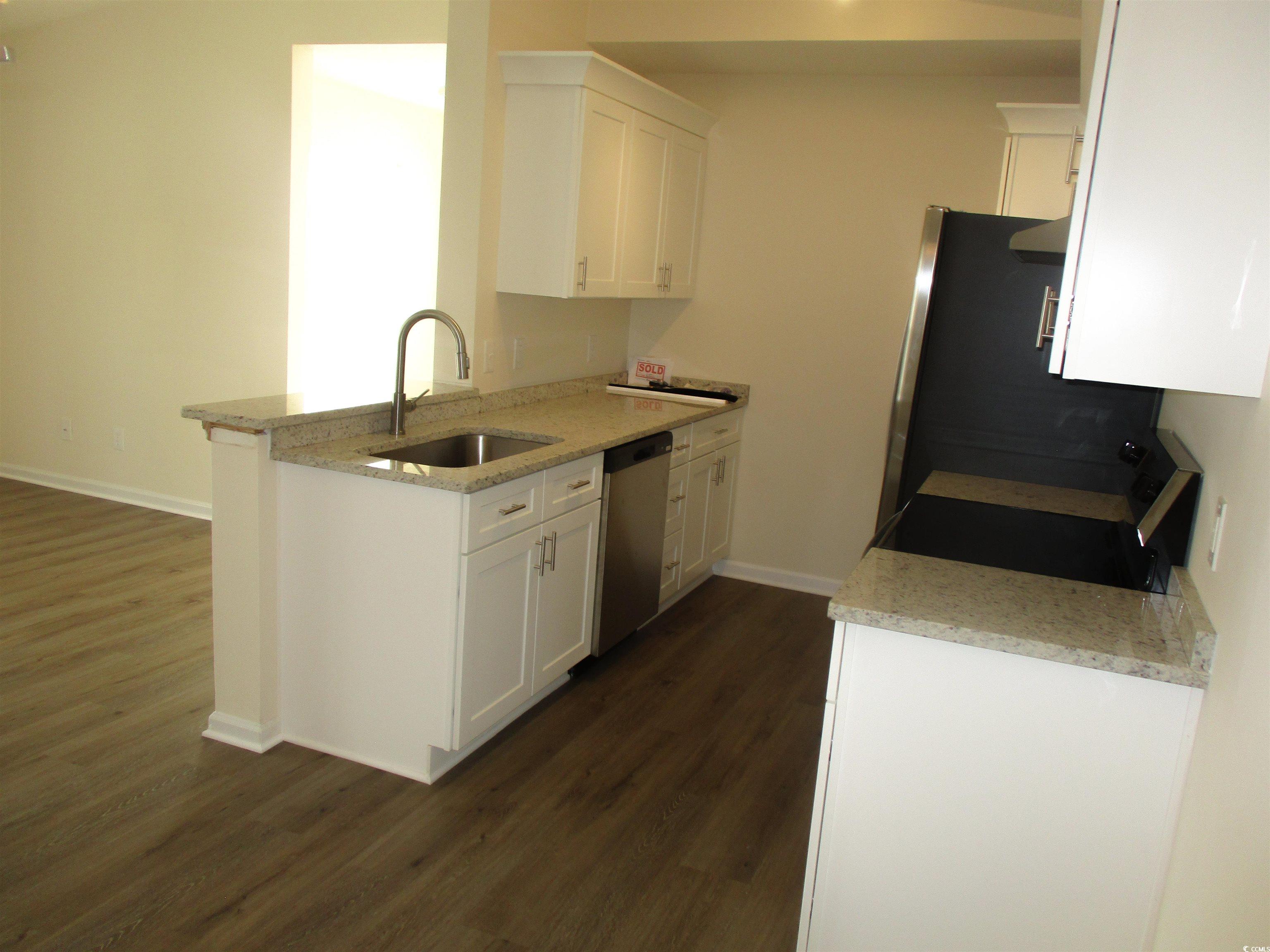 8545 Hopkins Circle Surfside Beach, SC 29575 - Photo 5 of 24 Kitchen with light stone counters, white cabinetry, black range with electric stovetop, dark wood-type flooring, and stainless steel dishwasher