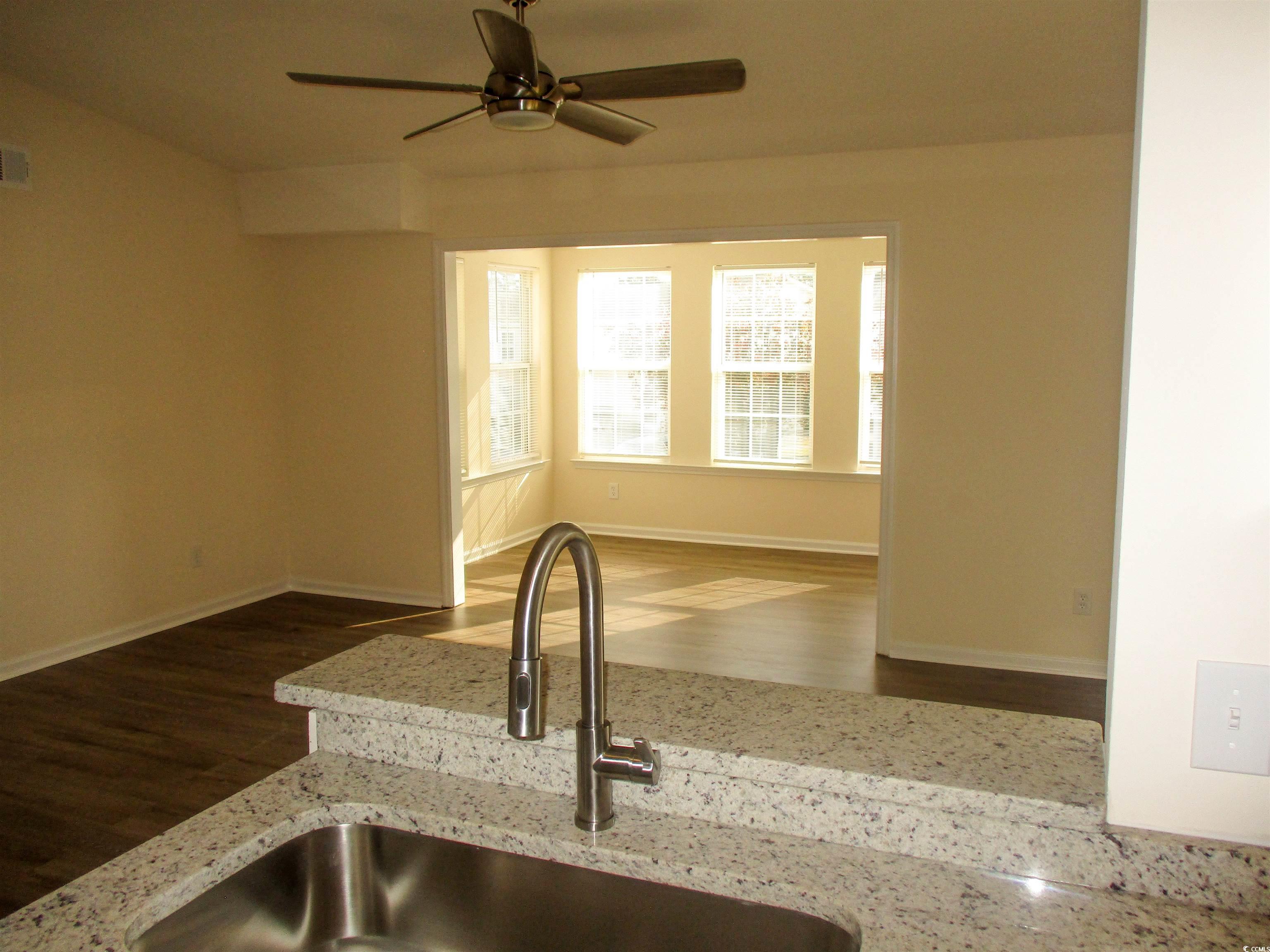 8545 Hopkins Circle Surfside Beach, SC 29575 - Photo 22 of 24 Kitchen with a ceiling fan, light stone countertops, open floor plan, and wood finished floors