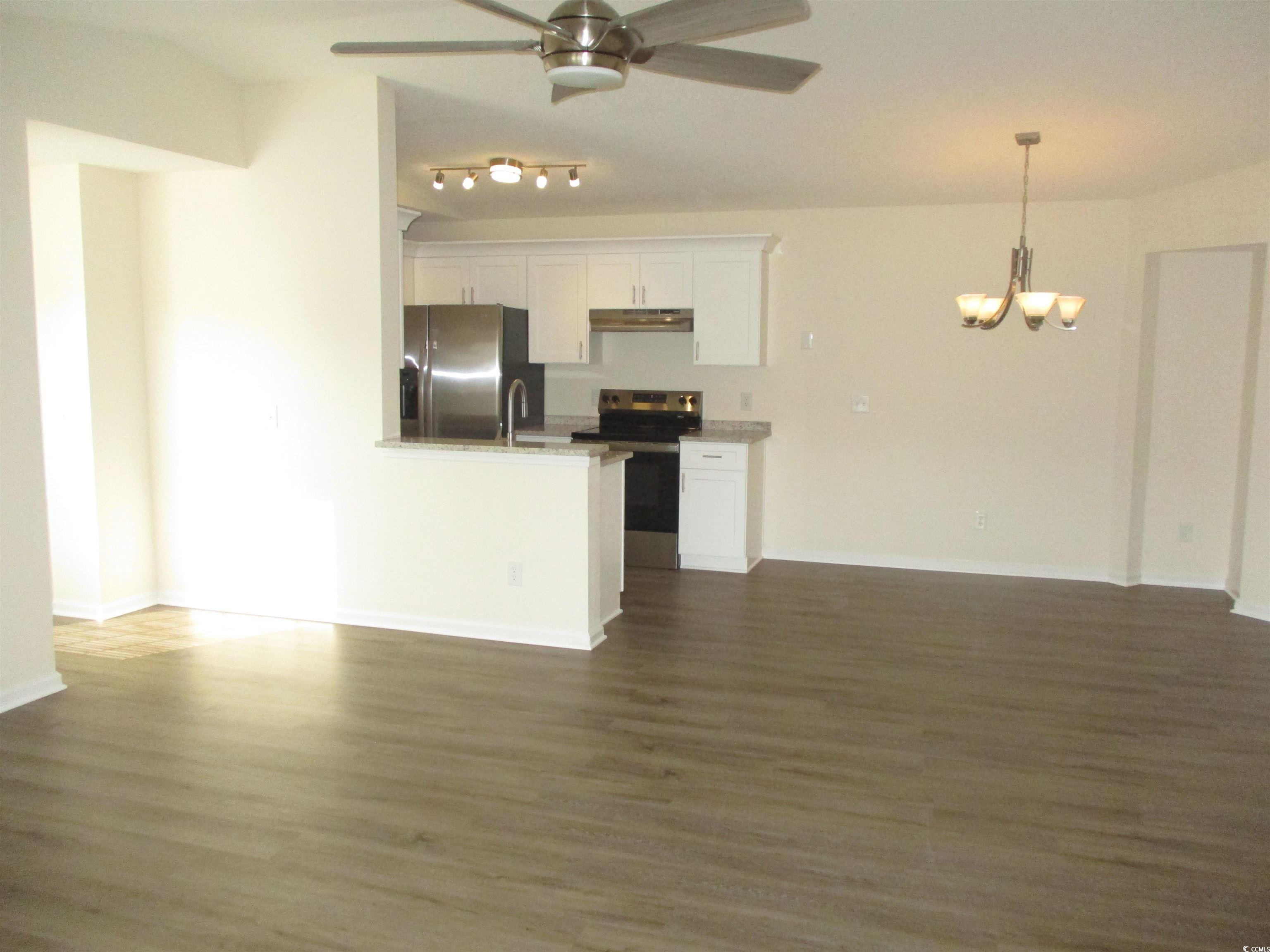 8545 Hopkins Circle Surfside Beach, SC 29575 - Photo 23 of 24 Kitchen with white cabinets, open floor plan, stainless steel appliances, a ceiling fan, and dark wood finished floors