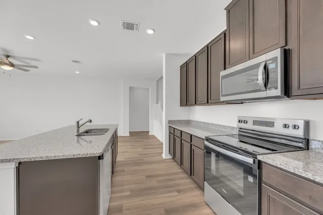 a kitchen with stainless steel appliances granite countertop a sink stove and microwave