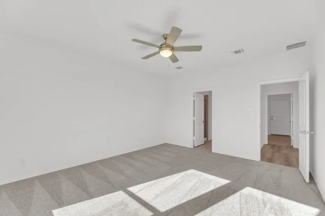 an empty room with closet and windows