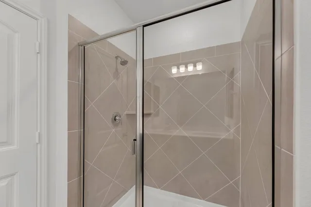 a bathroom with a glass shower door and a bathtub