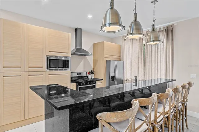 a kitchen with stainless steel appliances a sink a stove and white cabinets