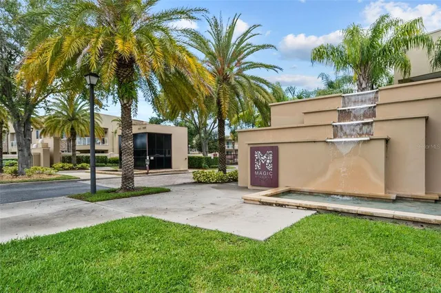 a view of a house with a yard and palm trees