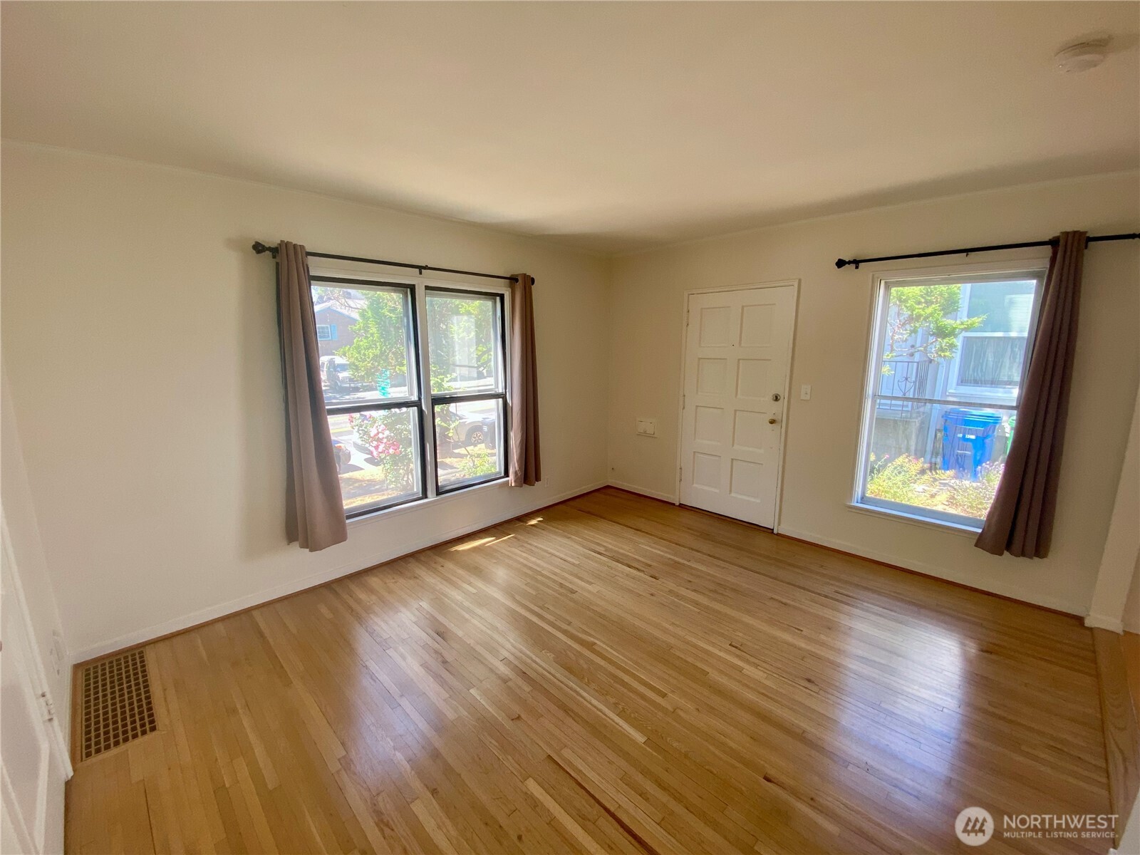 5708 8th Avenue Northwest Seattle, WA 98107 - Photo 4 of 15 a view of an empty room with wooden floor and a window