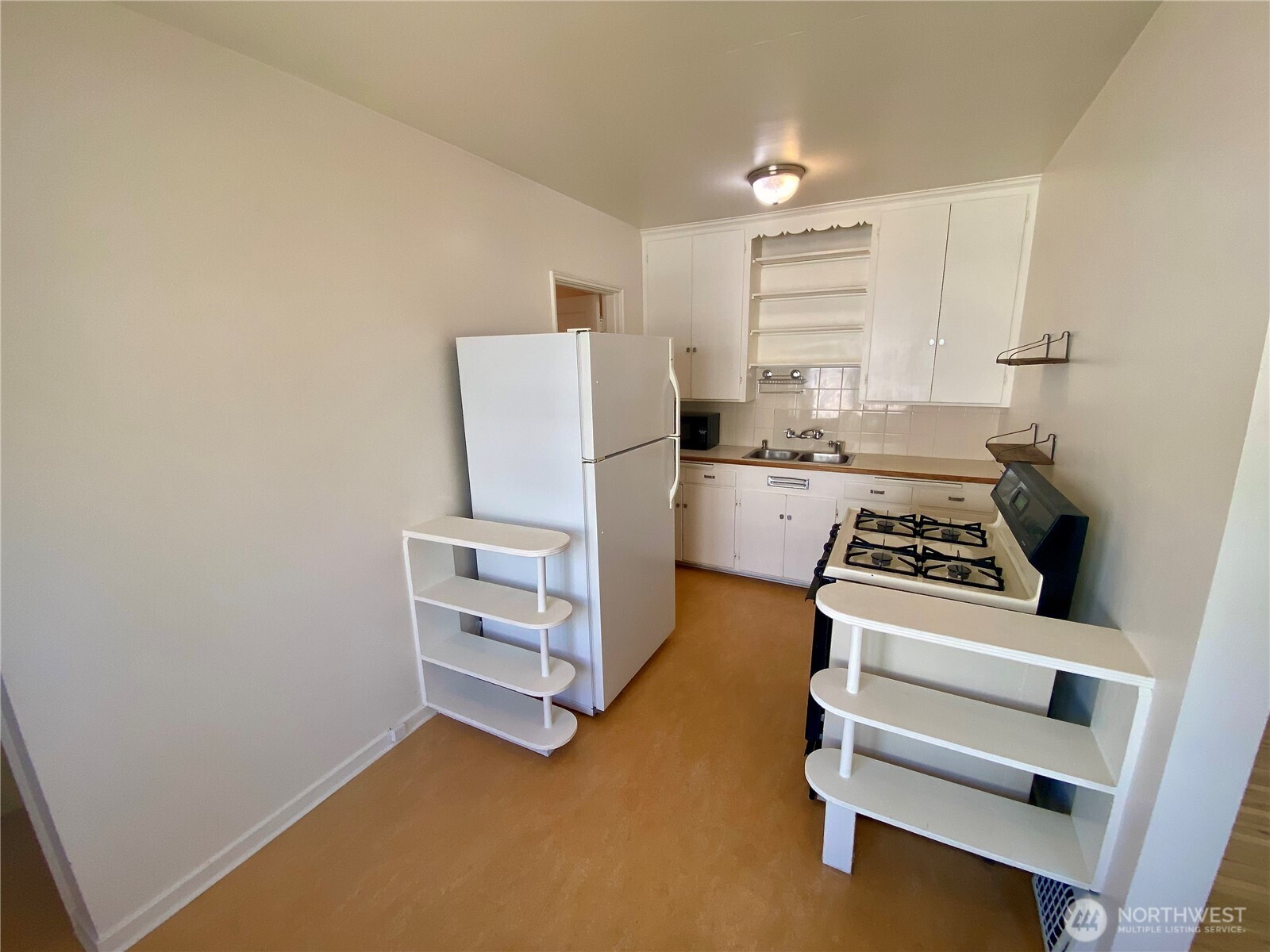 5708 8th Avenue Northwest Seattle, WA 98107 - Photo 7 of 15 a kitchen with a stove and a refrigerator