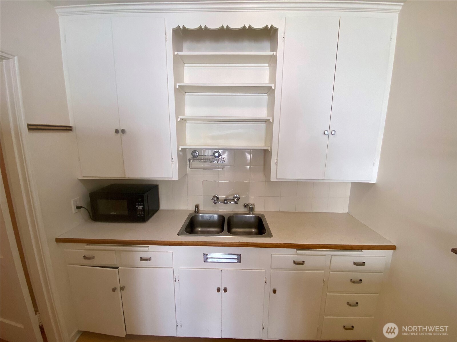 5708 8th Avenue Northwest Seattle, WA 98107 - Photo 8 of 15 a kitchen with a microwave a stove and cabinets