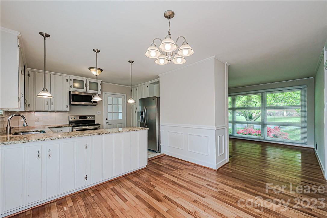 4301 Applegate Road Charlotte, NC 28209 - Photo 11 of 21 a kitchen with a sink chandelier and stainless steel appliances