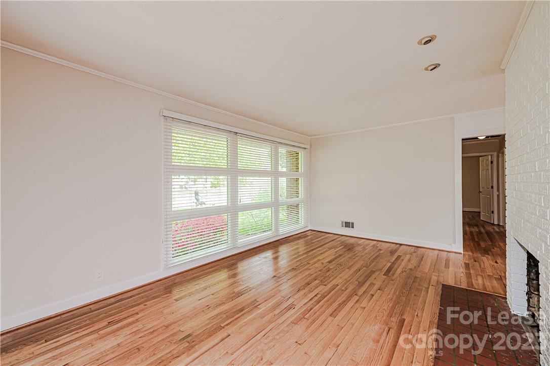 4301 Applegate Road Charlotte, NC 28209 - Photo 4 of 21 an empty room with wooden floor and windows