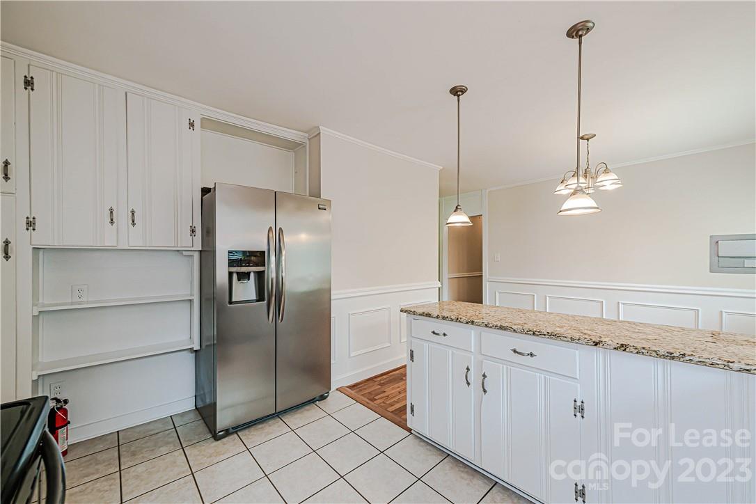 4301 Applegate Road Charlotte, NC 28209 - Photo 9 of 21 a kitchen with white cabinets and refrigerator