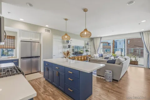 a large kitchen with stainless steel appliances granite countertop a stove a refrigerator and a large countertops with wooden floor