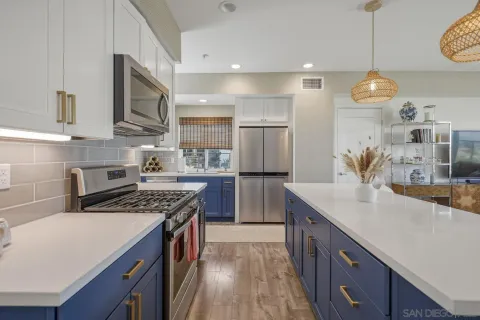 a kitchen with stainless steel appliances granite countertop a sink a stove and a wooden floors