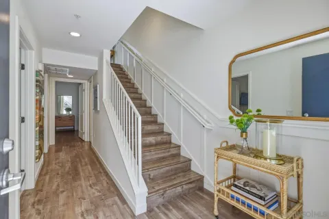a kitchen with stainless steel appliances granite countertop a stove top oven a sink dishwasher a refrigerator and cabinets with wooden floor