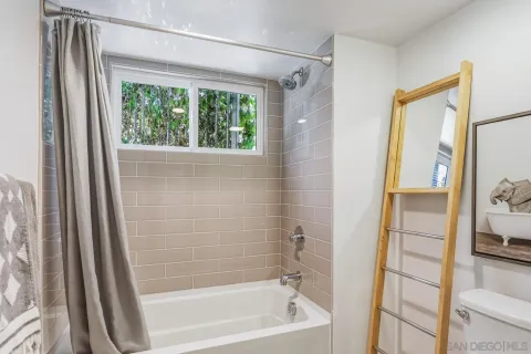 a bathroom with a tub a sink and a large mirror